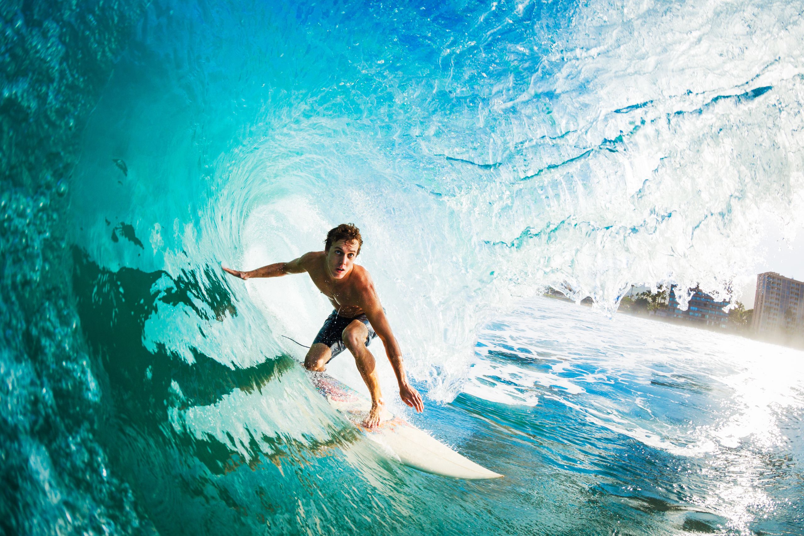 Close-up of a surfer riding a large blue wave